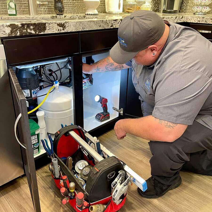 plumber repairing a garbage disposal