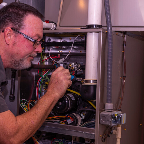 furnace tech working on an HVAC pressure switch